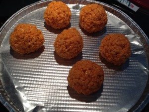 Using 1/2-cup measuring cup coated with cooking spray divide warm cereal mixture into 12 portions. Using buttered hands shape each portion into pumpkin shape around one candy piece.